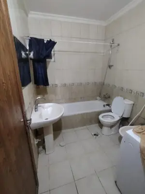 a bathroom with a toilet and a tub and a sink at الشهم 10 in Irbid
