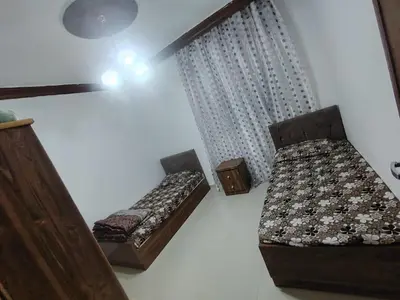 a room with two beds and two chairs in it at الشهم 10 in Irbid
