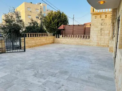 a courtyard with a stone floor and a fence at Luxurious furnished apartment for rent with hotel finishes in Amman