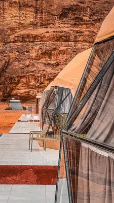 a group of tents in front of a canyon at Nala Luxury Camp & Bubbles Hotel in Wadi Rum