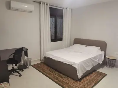 a bedroom with a bed and a desk and a chair at 2 Master Bedroom Deluxe Apartment Queen Alia Airport Families Women ONLY in Amman