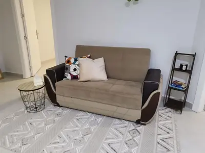 a brown couch with pillows on it in a living room at 2 Master Bedroom Deluxe Apartment Queen Alia Airport Families Women ONLY in Amman