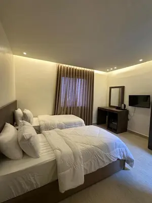 a hotel room with two beds and a television at Midtown Lweibdeh Hostel in Amman