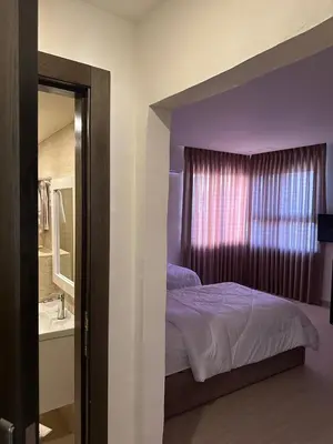 a bedroom with a bed and a sink and a window at Midtown Lweibdeh Hostel in Amman