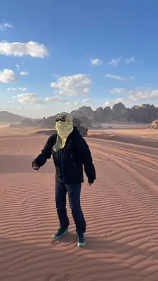 a person walking in the desert with a mask on at wadi rum planet camp in Disah