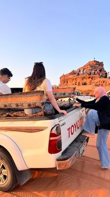 a group of people in the back of a truck in the desert at wadi rum planet camp in Disah