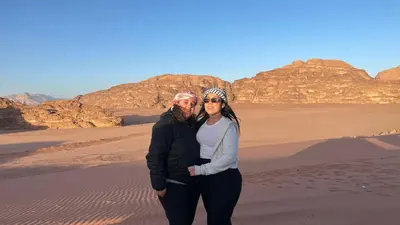 a man and a woman standing in the desert at wadi rum planet camp in Disah
