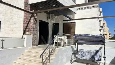 a porch with a cart on the front of a house at شقة مفروشة ثلاث غرف الجاردنز in Amman