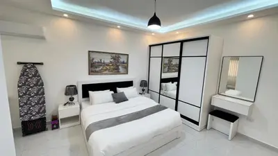 a white bedroom with a large white bed in it at شقة مفروشة ثلاث غرف الجاردنز in Amman