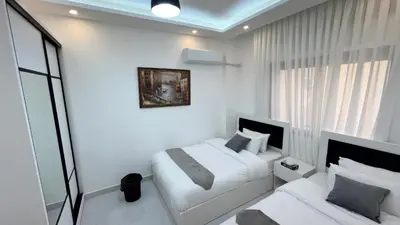a bedroom with two beds and a window at شقة مفروشة ثلاث غرف الجاردنز in Amman