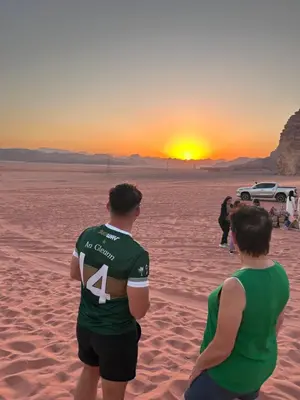 two people standing on the beach watching the sunset at Lamis Camp Wadi Rum in Aqaba