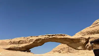 a rock arch in the desert against a blue sky at Lamis Camp Wadi Rum in Aqaba