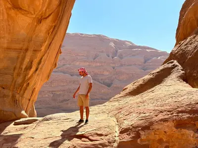 a man standing on a rock in a canyon at Stars Night Camp in Wadi Rum