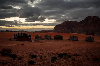 a group of buildings in the desert under a cloudy sky at Stars Night Camp in Wadi Rum