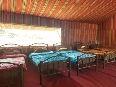 a group of four beds in a room at Stars Night Camp in Wadi Rum