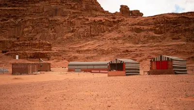 two benches in the desert with a mountain in the background at Stars Night Camp in Wadi Rum
