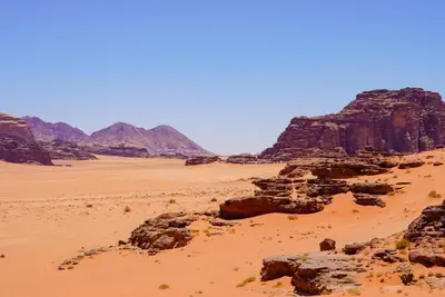 a view of the desert with mountains in the background at Dune Camp Tours in Wadi Rum