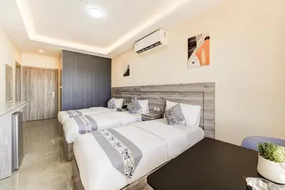 two beds in a hotel room with a table at aqaba hills hotel in Aqaba