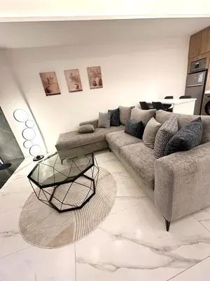 a living room with a couch and a table at Brand New Stylish Luxe Apartment Near US Embassy Abdoun in Amman
