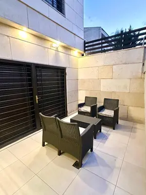 a patio with benches and tables on a building at Brand New Stylish Luxe Apartment Near US Embassy Abdoun in Amman