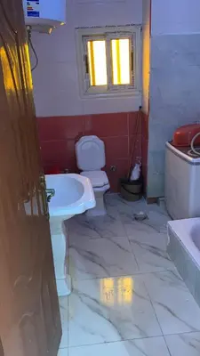 a bathroom with a toilet and a sink and a window at Family house in Petra