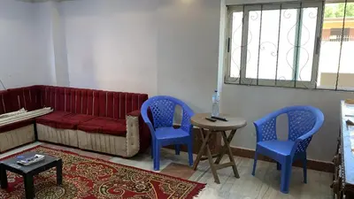 a living room with blue chairs and a red couch at Family house in Petra