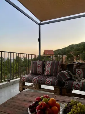 a living room with a couch and a bowl of fruit at أكواخ المها oryx cottage in Ajloun