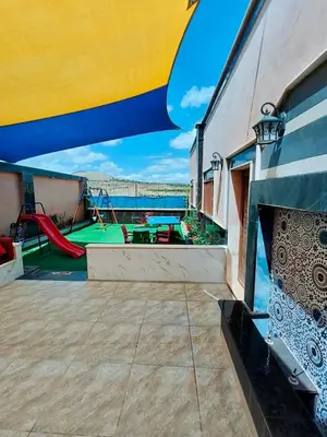 a balcony with a slide and a playground at شاليه كل الفصول in Dawqarah