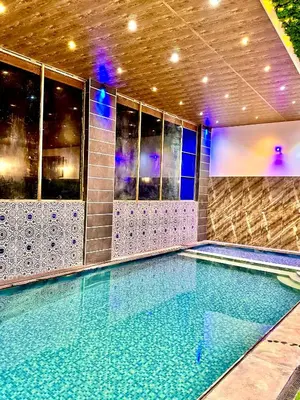 a swimming pool in a building with a swimming pool at شاليه كل الفصول in Dawqarah