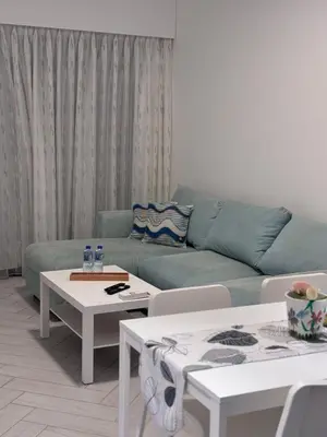 a living room with a blue couch and tables at العقبة in Aqaba