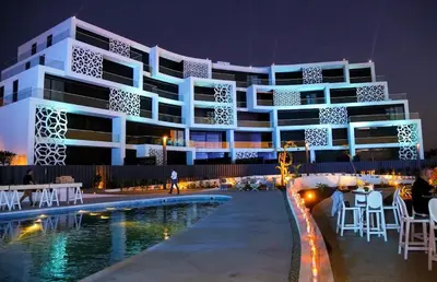 a building with a swimming pool at night at Ayla Oasis Golf Apartment - Ayla Vista in Aqaba