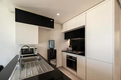 a kitchen with white cabinets and a sink at Ayla Oasis Golf Apartment - Ayla Vista in Aqaba