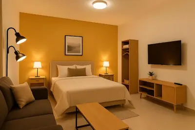 a bedroom with a bed and a couch and a tv at Stay with Obada Private Room in Amman