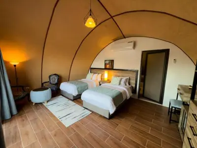 a bedroom with two beds in a room at Luxury Spiral Camp in Maḩaţţat Dīsah
