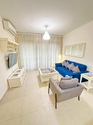 a living room with a blue couch and a chair at Abdoun Modern 2BR Apartment Near US Embassy in Amman