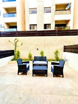 a patio with four chairs and a table and a building at Abdoun Modern 2BR Apartment Near US Embassy in Amman