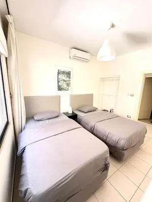 a bedroom with two beds and a room with at Abdoun Modern 2BR Apartment Near US Embassy in Amman