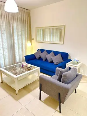 a living room with a blue couch and a coffee table at Abdoun Modern 2BR Apartment Near US Embassy in Amman