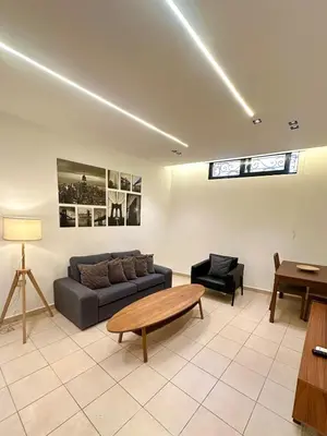 a living room with a couch and a table at Abdoun Modern Apartment Near US Embassy in Amman