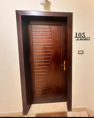 a wooden elevator door in a building at Abdoun Modern Apartment Near US Embassy in Amman