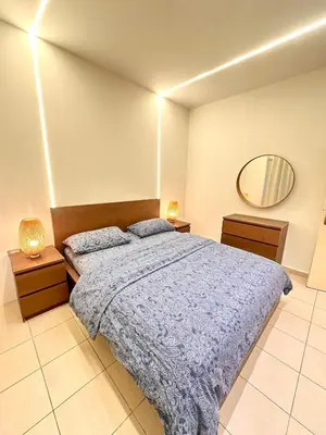 a bedroom with a large bed and a mirror at Abdoun Modern Apartment Near US Embassy in Amman