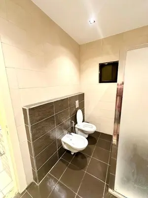 a bathroom with two toilets and a sink and a shower at Abdoun Modern Apartment Near US Embassy in Amman