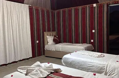 two beds in a room with red and white stripes at ATAYA sunrise camp in Disah