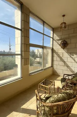 a living room with two chairs and two windows at 3 Bedroom Family Apartment in Amman in Amman