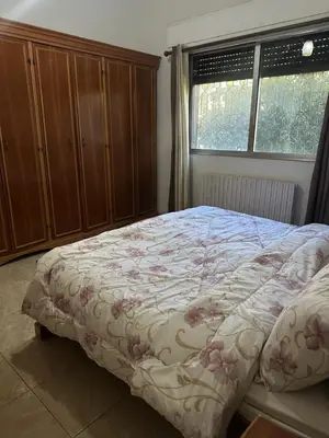 a bedroom with a bed with a floral comforter at 3 Bedroom Family Apartment in Amman in Amman