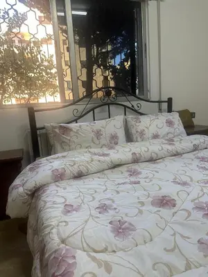 a bed with pink flowers on it in a bedroom at 3 Bedroom Family Apartment in Amman in Amman