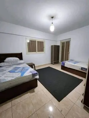 a bedroom with two beds and a rug at Safari home in Petra