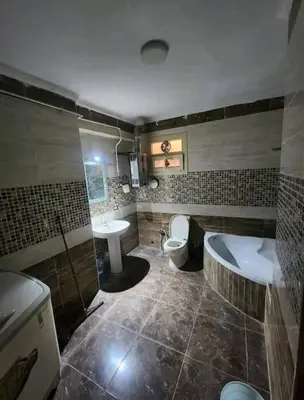 a bathroom with a tub and a toilet and a sink at Safari home in Petra