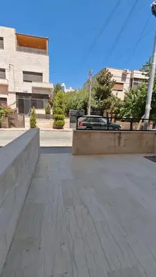 an empty street with a car in a parking lot at شقة في ضاحية الرشيد in Amman