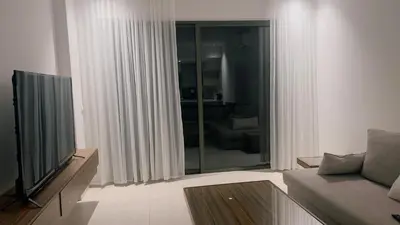 a living room with a couch and a television at شقه بغرفة نوم في قريه الراحة one bedroom apartment in alraha village in Al Jafr